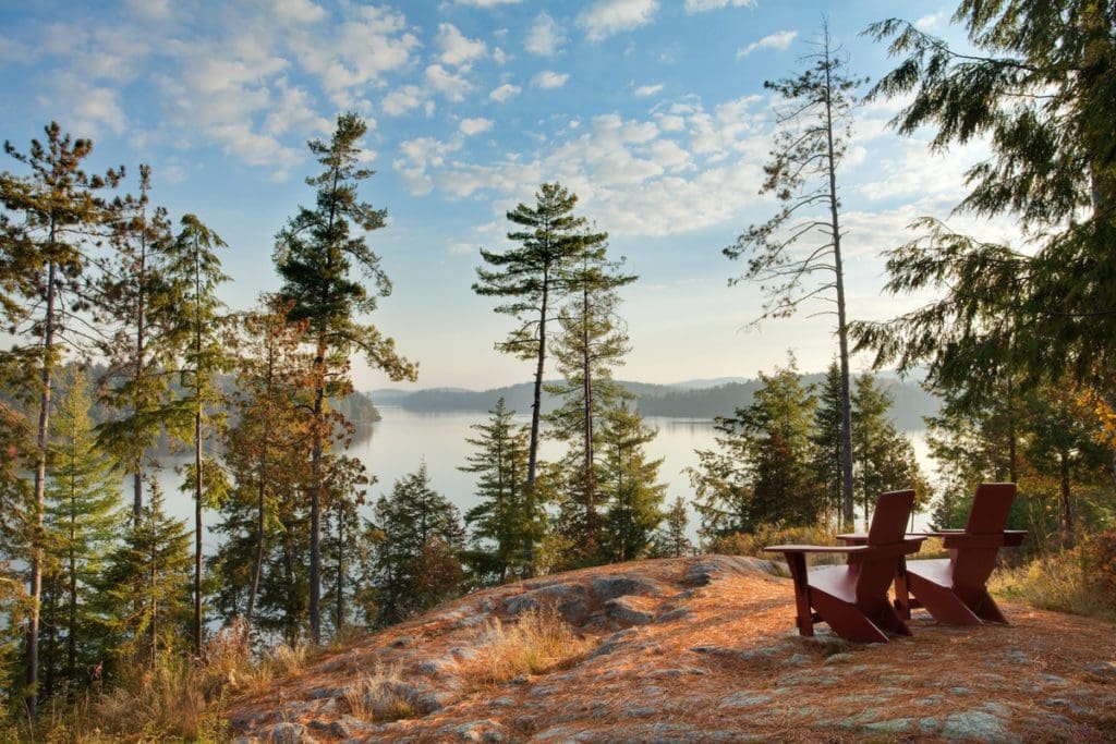 Two Adirondack chairs face the lake at The Point at sunset.