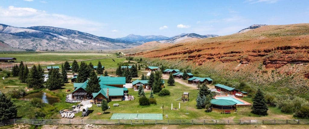 An aerial view of the spacious resort buildings and grounds of Red Rock Ranch, nestled in Wyoming.