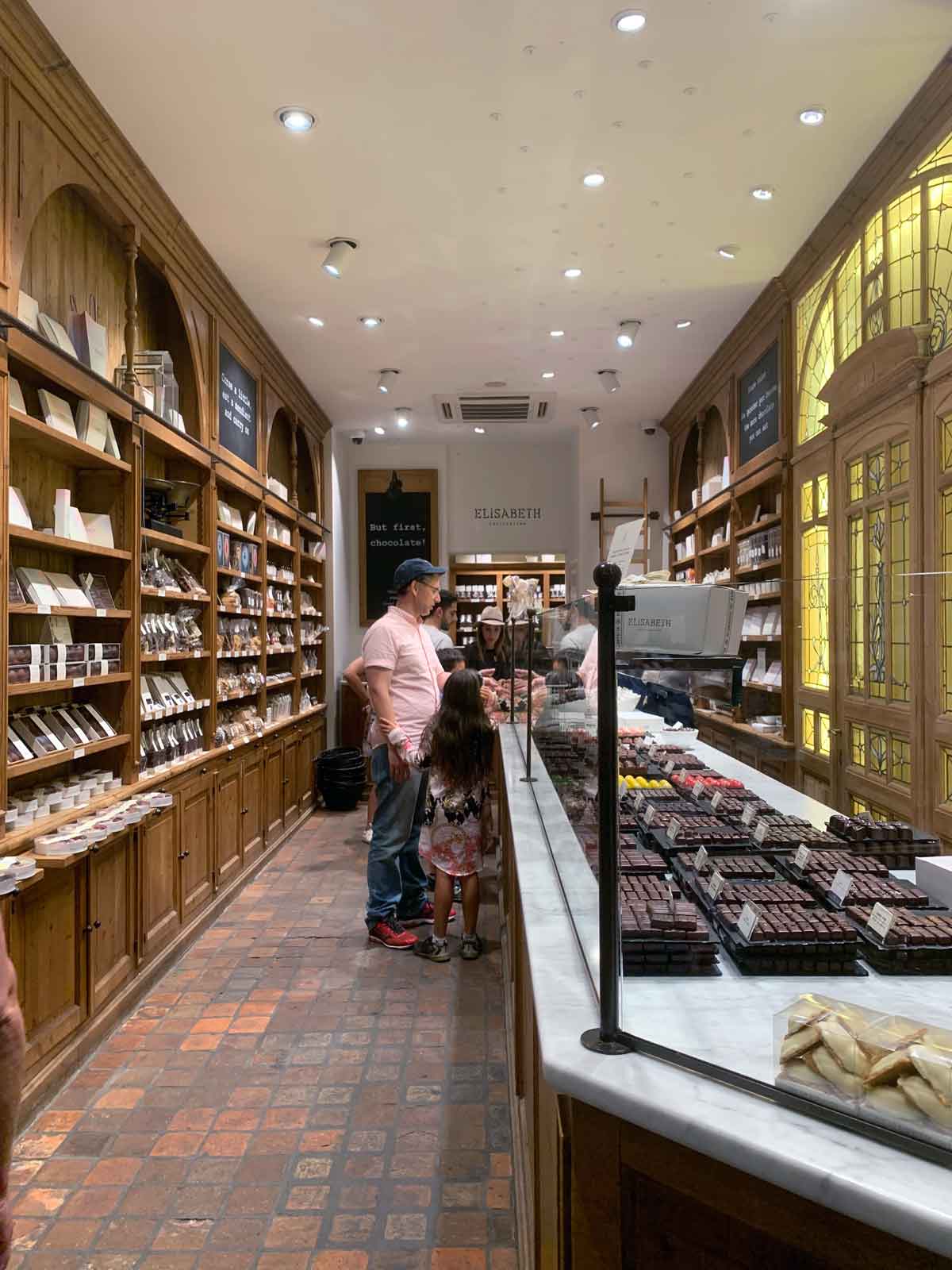 A family looks at desserts in a case in a chocolate shop in Brussels.