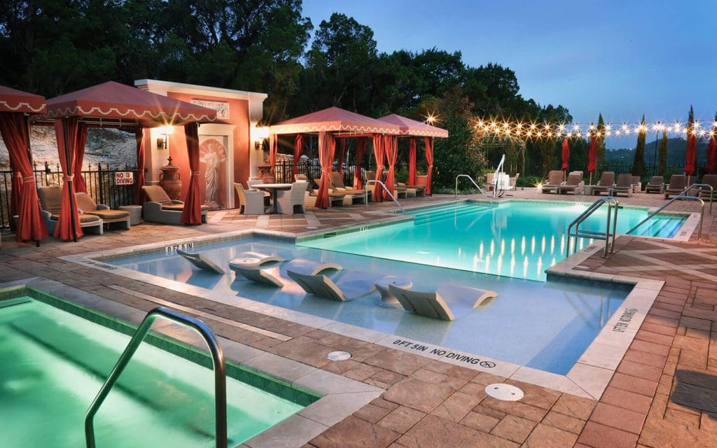 The outdoor pool and surrounding cabanas at Hotel Granduca Austin at dusk.