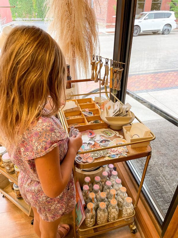 A young girl looks a stickers, while shopping at Hello Adorn, one of the best things to do in Eau Claire with kids.