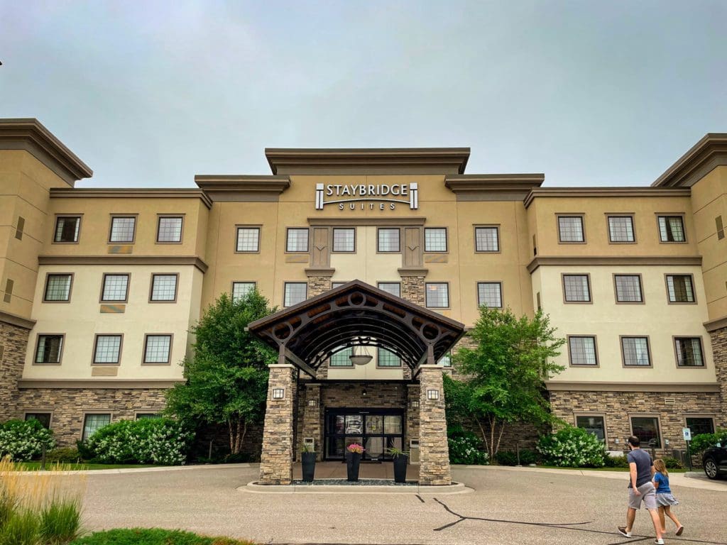 A dad and his young daughter walk into the Staybridge Suites Eau Claire - Altoona.