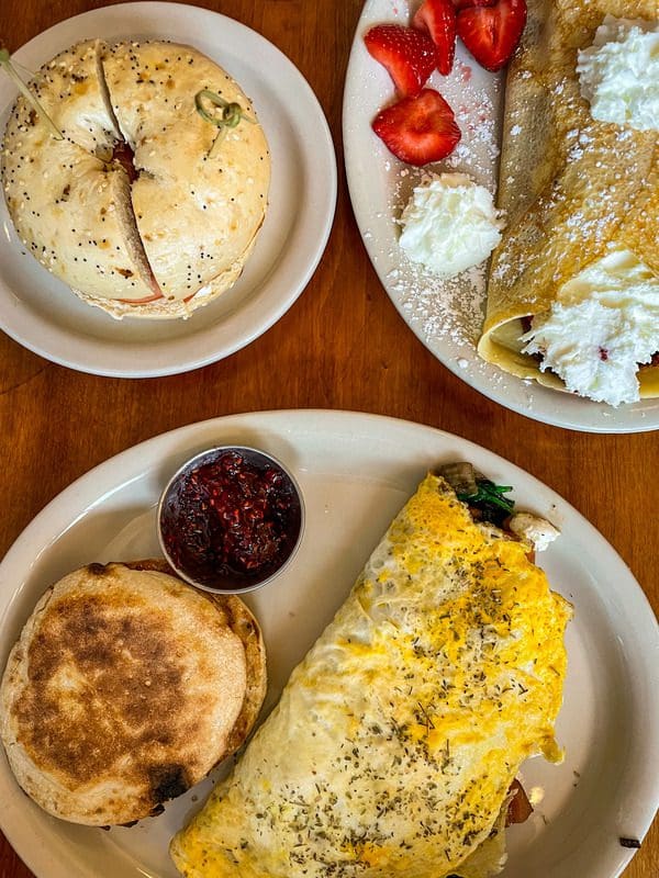 A plate of breakfast food at The Nucleus, in Eau Claire, including an omelet and bagel sandwhich.