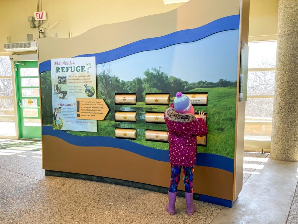 A young girl reads an exhibit with the Nature Center at Minnesota Valley National Wildlife Refuge.