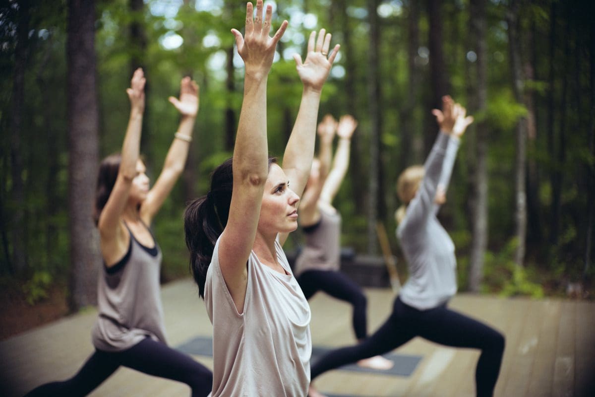 Several women practice deep healing woods yoga at Blackberry Farm.