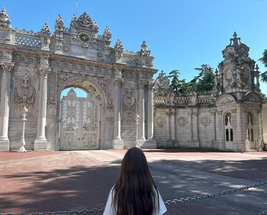 A young girl walks toward a grand arch on the grounds of Dolmabahçe Palace, a great stop on a Turkey itinerary for families.