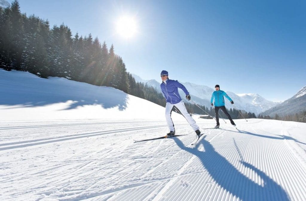 Two people embark on a cross-country skiing run courtesy of Hotel Alpendorf.