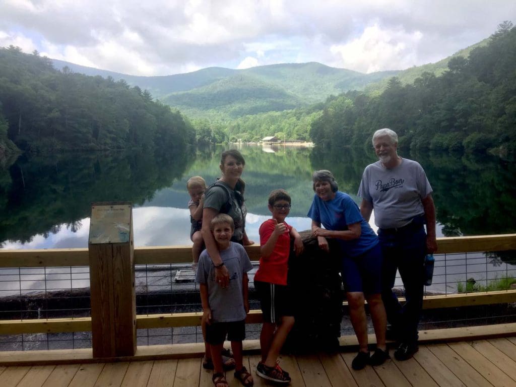 A family of six stands together with a view of Vogel State Park behind them.