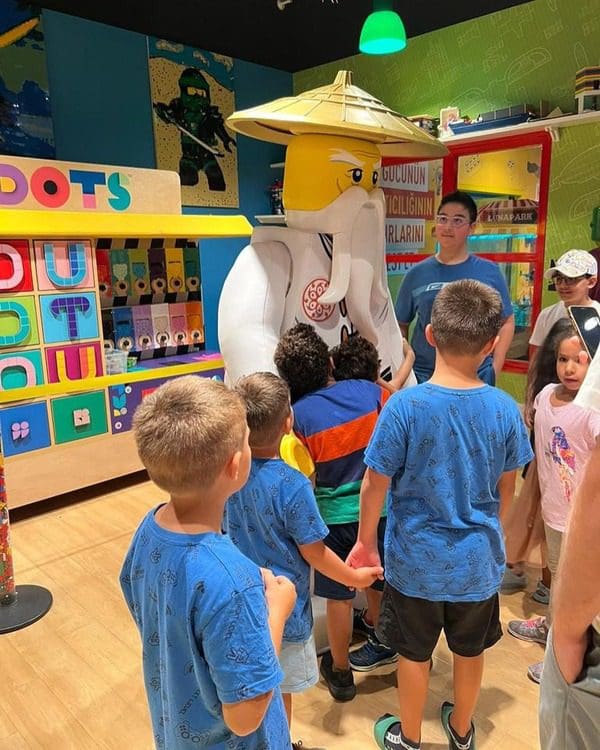 Kids line up to take a picture with a lego mascot at LEGOLAND Discovery Centre Istanbul.