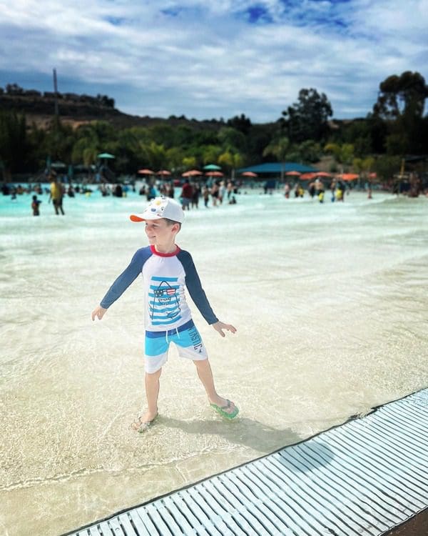 A young boy in swimwear enjoys the zero-depth pool at Sesame Place San Diego.