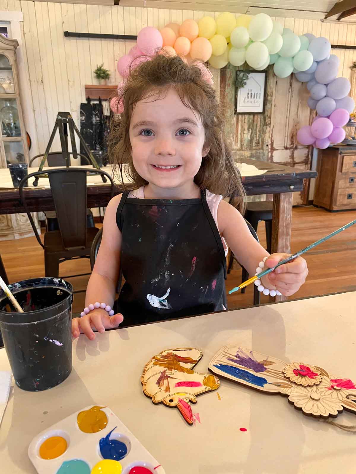 A young girl paints a craft at the Temecula Craft House.