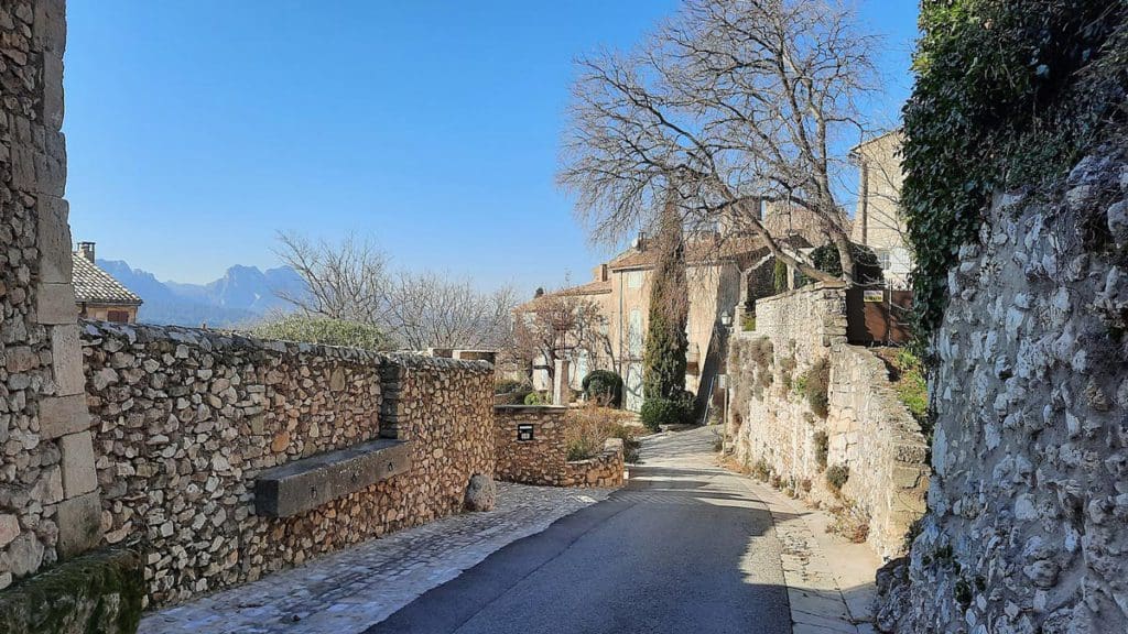 A winding street with charming stone walls in Eygalière, one of the best towns in the South of France with kids.