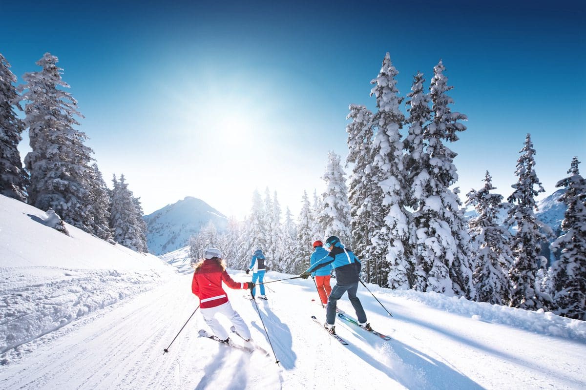 Several people on skis go down the slopes together in the Alpendorf region.