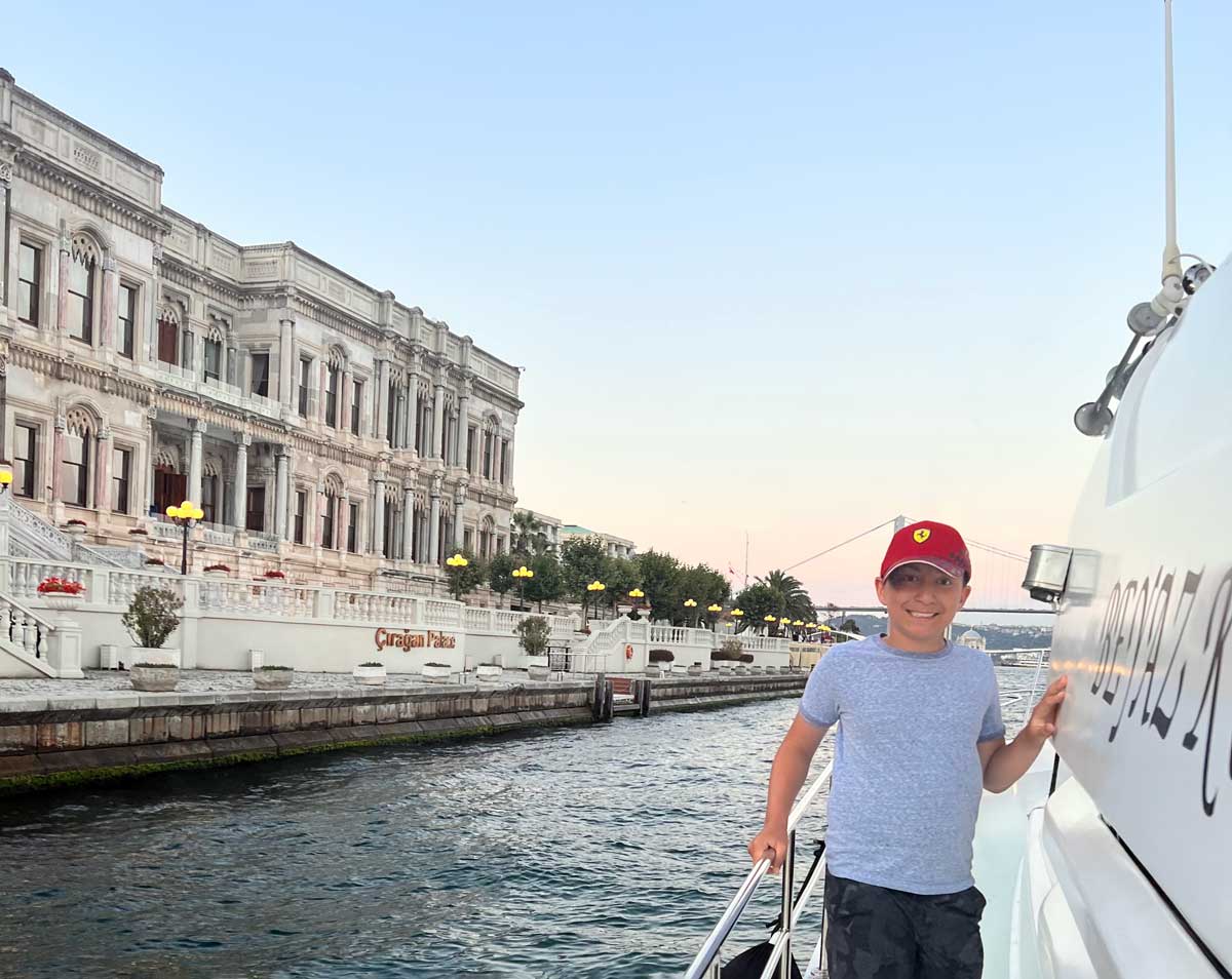 A young boy walks along the edge of a boat sailing in the Bosphorus, one of the best things to do on a family vacation to Istanbul.