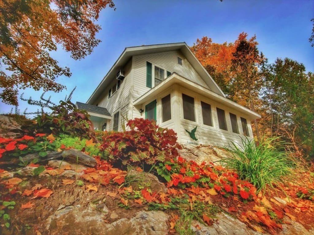 The main lodge of The Tyler Place Family Resort, surrounded by vibrant fall leaves on a sunny day.