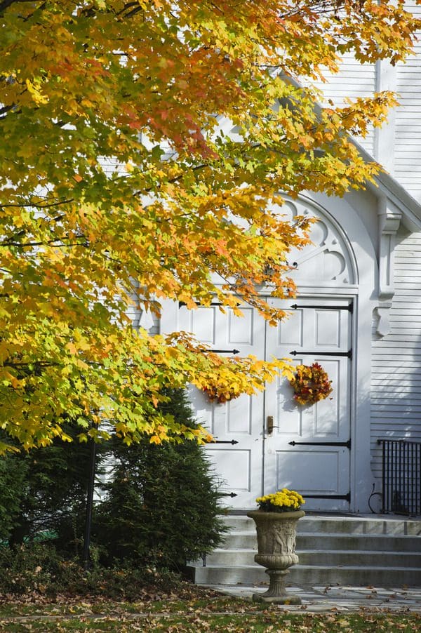 A close up of a church door in Bennington, covered in fall foliage.