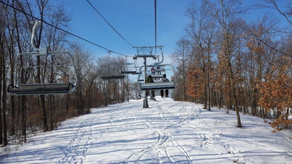 A ski lift takes people up the ski hill at Welch Village on a wintery day.