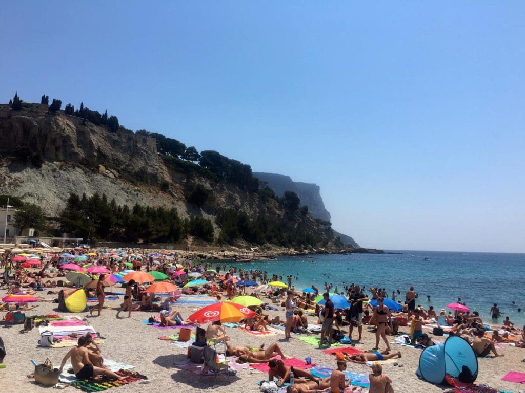 A beach filled with people in Cassis, France, one of the best places to visit in France with kids.