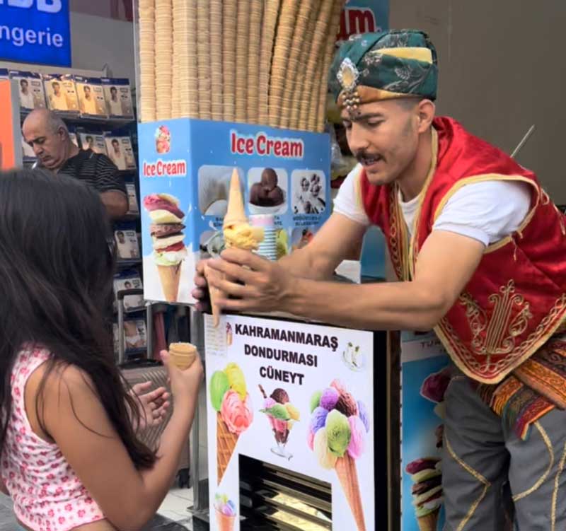 A man hands a young girl ice cream.