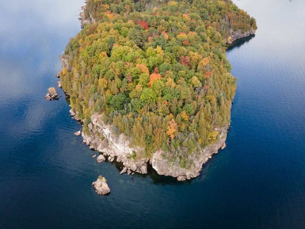 An aerial view of Lake Champlain, covered in fall colors, one of the best places to visit for fall in New England with kids.