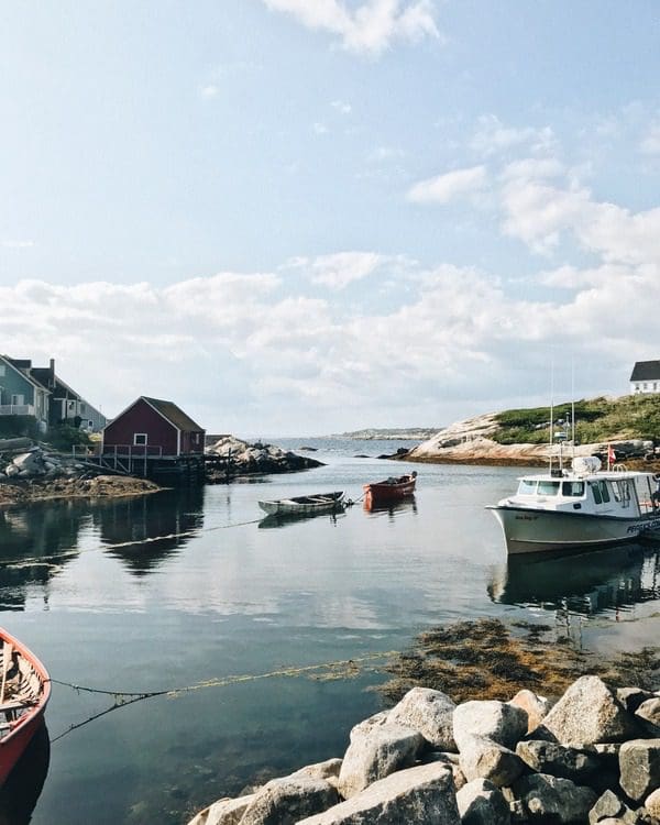 A lovely bay of water in Nova Scotia, with boats in the water and fishing shacks on shore.