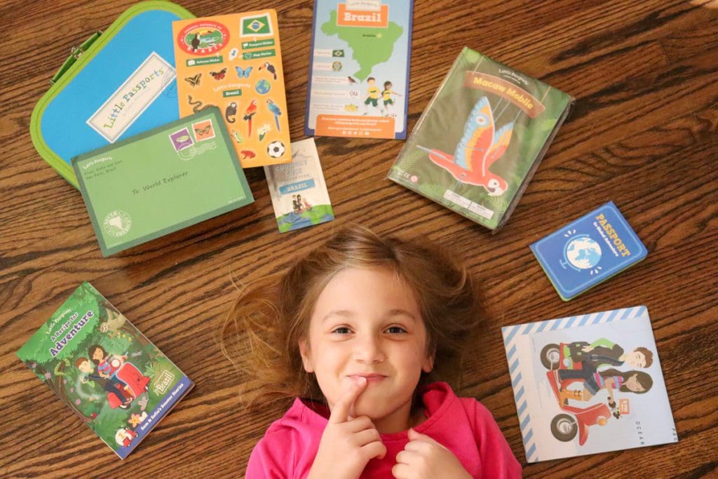 A young girl gets curious, with a variety of Little Passports activities laying around her.