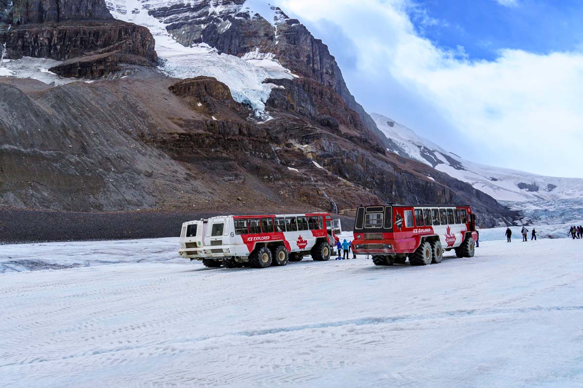 Two tour vehicles sit at the Athabasca Glacier Columbia Ice Field near Jasper.