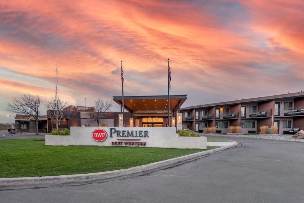 The exterior entrance of Best Western Premier Denver East at sunset.