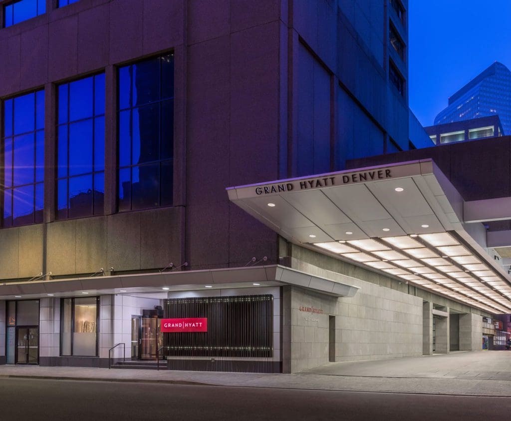 The exterior entrance to Grand Hyatt Denver, well-lit at night, one of the best Denver hotels for families.