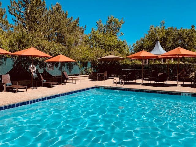 The outdoor pool at Hilton Denver Inverness with cabanas on the pool deck.