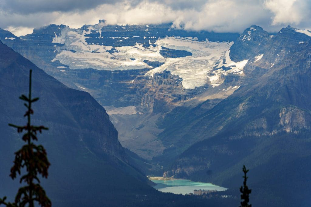 A view of Lake Louise nestled between snow-capped mountains.