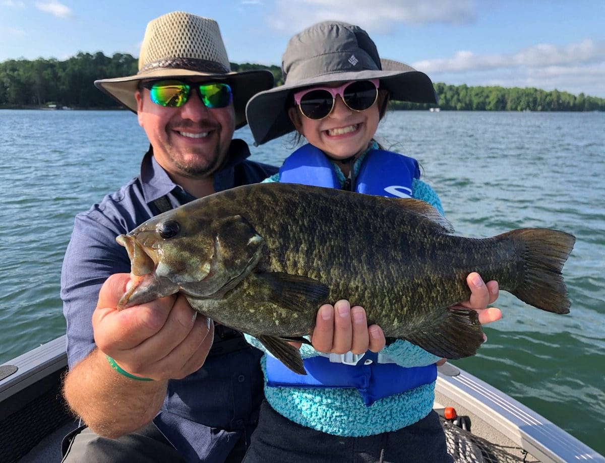 A father and his son hold out a big fish, while fishing on a boat on a lake in Brainerd.