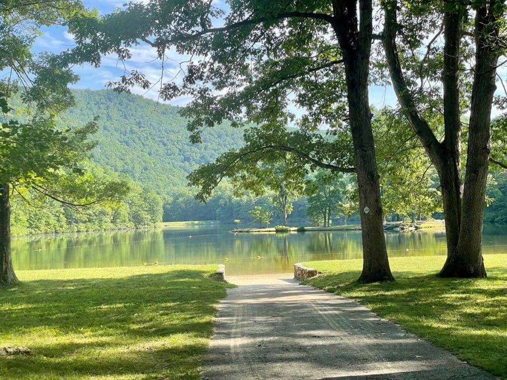 A did road leads to Sherando Lake flanked by lush trees, one of the best lake getaways near Washington DC for families.