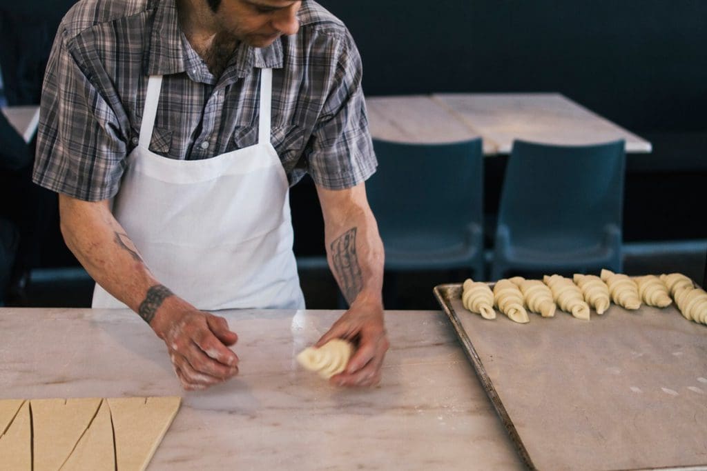 A man rolls croissants at the Market Hall attached to The Source Hotel.