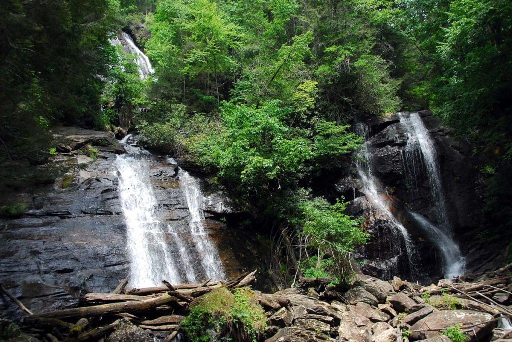 Waterfalls cascade down carves rocks, surrounded by lush foliage, in Unicoi State Park.