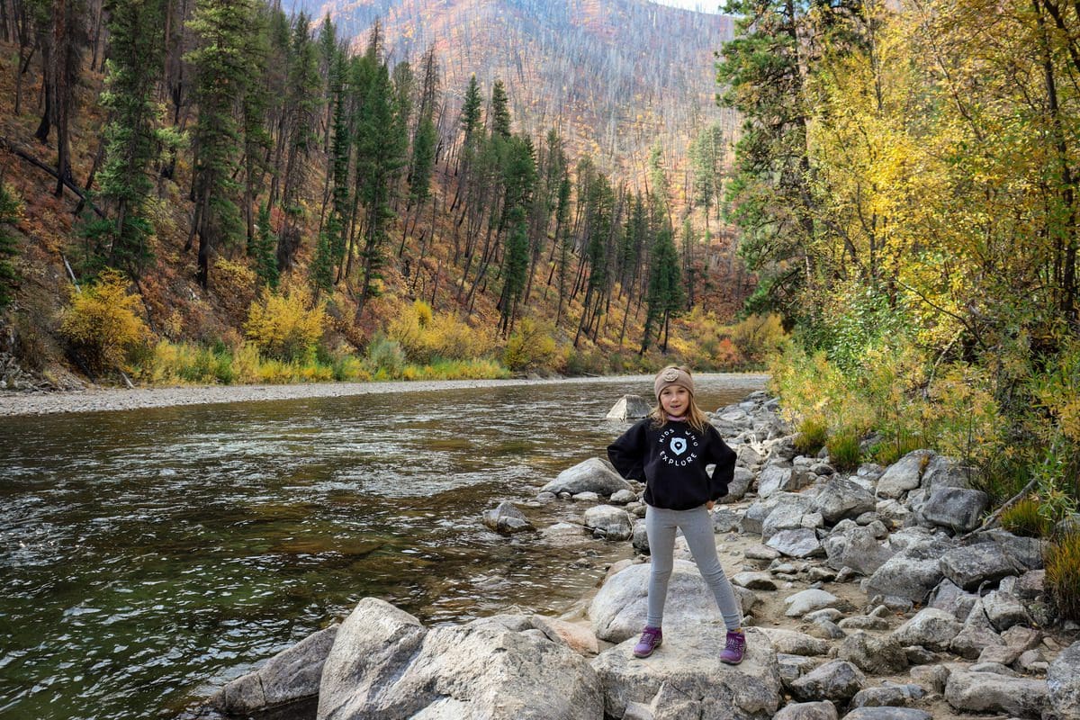 A young girl stands proudly near a river at Boise National Forest.