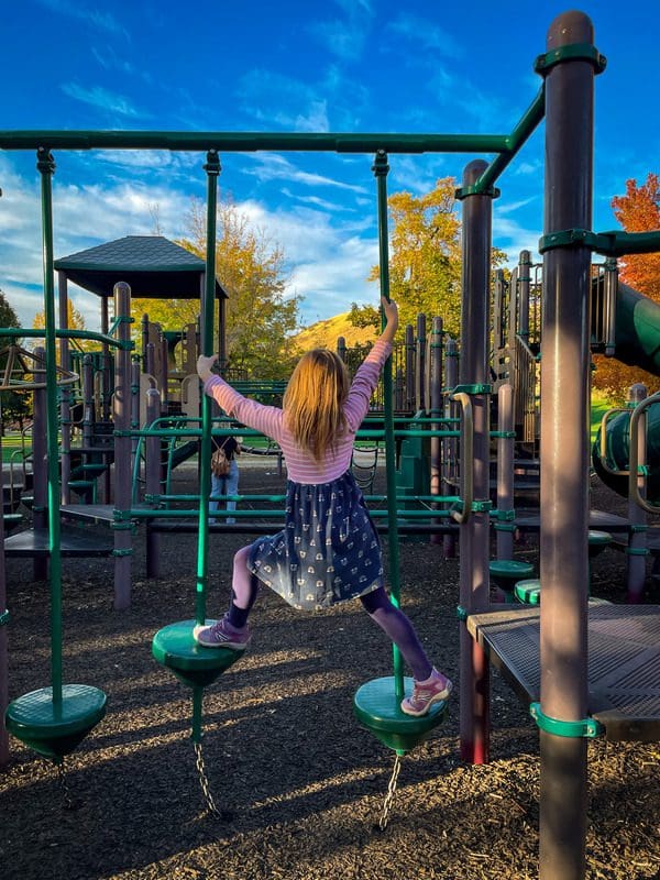 A young girl makes her way across playground equipment at Camel's Back Park, near the Hyde Park neighborhood, one of the best things to do in Boise with kids