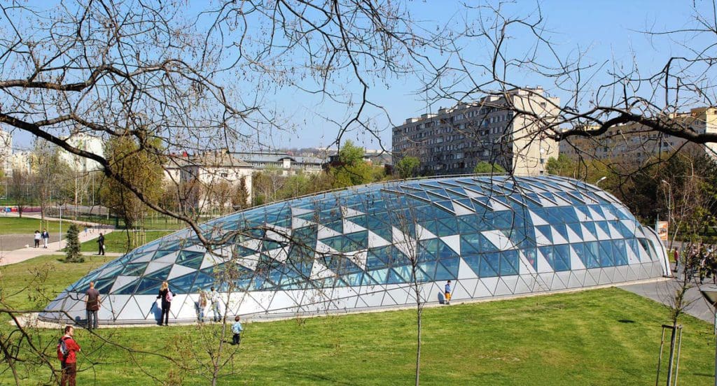 A view of Bikás park metro station through the trees.