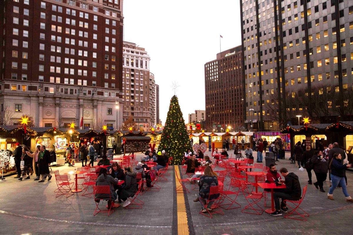 Several rows of tables set up, waiting for diners, at Christmas Village, one of the best christmas markets in the United States for families.