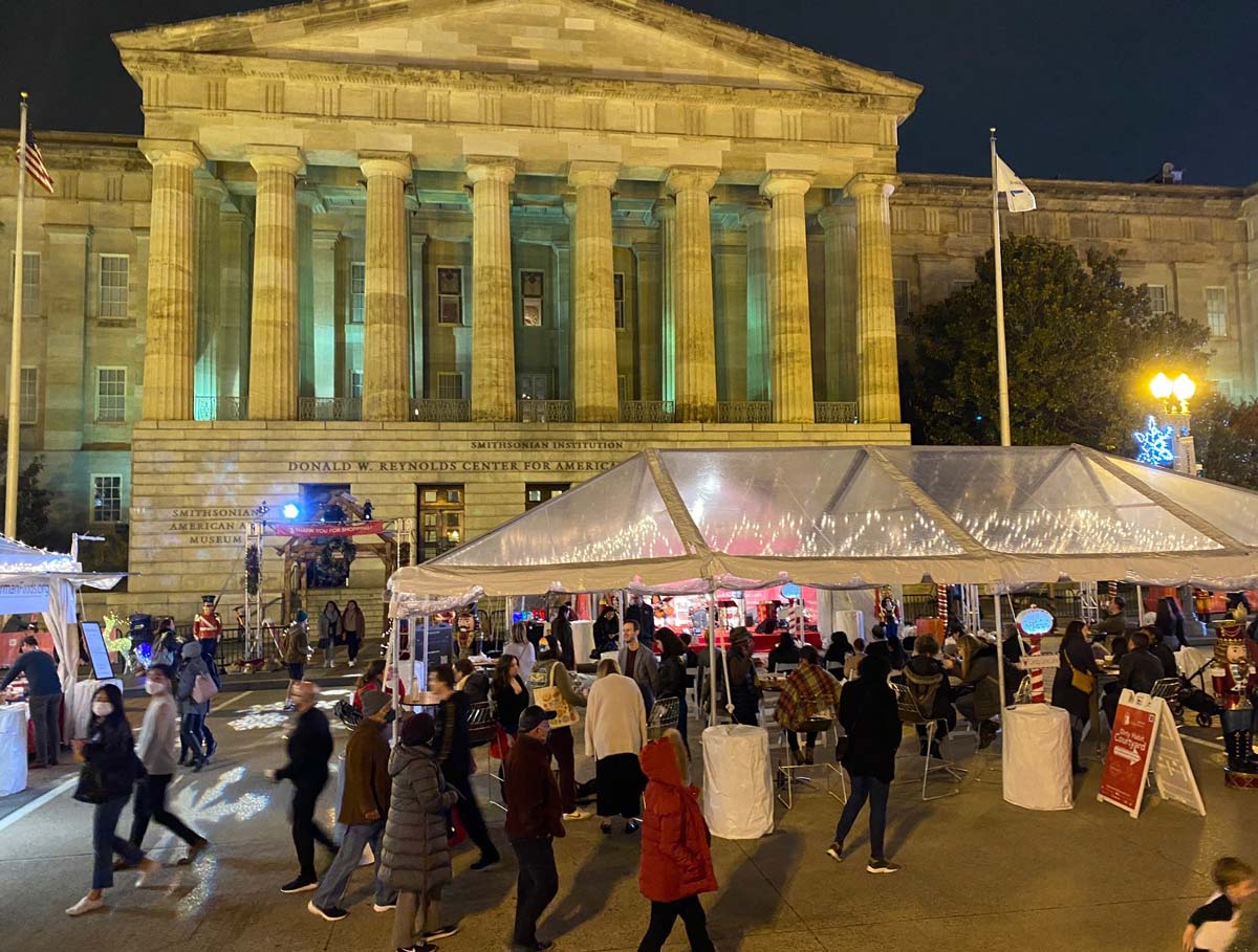 A crowd of people meander the vendors at Downtown Holiday Market, one of the best christmas markets in the United States for families.