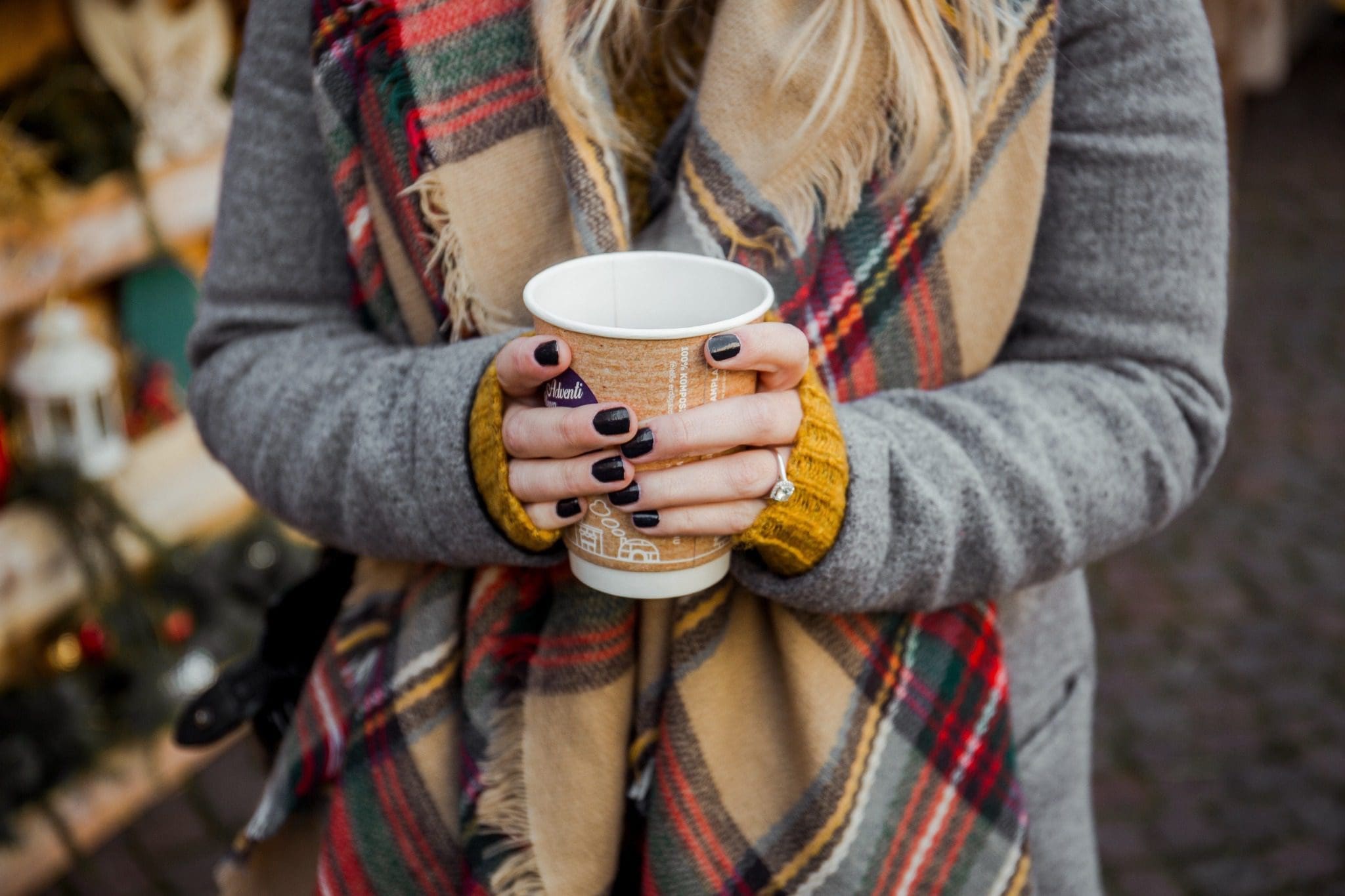 A woman's hands hold onto a cup of cocoa while she explores the Christkindlmarkt Frankenmuth.