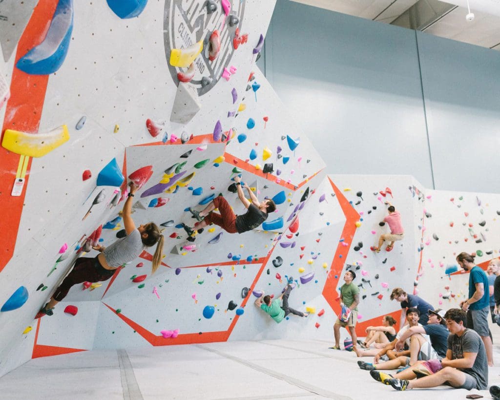 People boulder along a wall at High Point Climbing Gym.