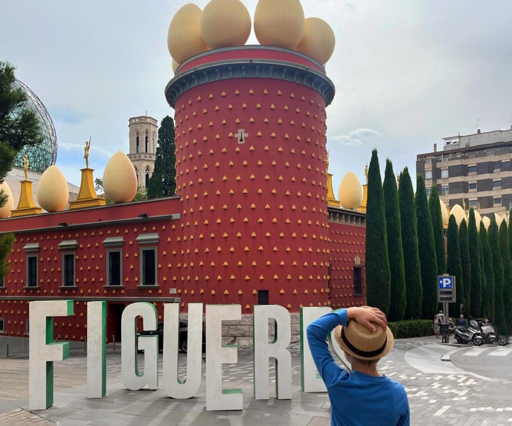 A young boy stands in front of an outdoor exhibit at the Salvador Dali Museum, one of the best museums in France with kids.