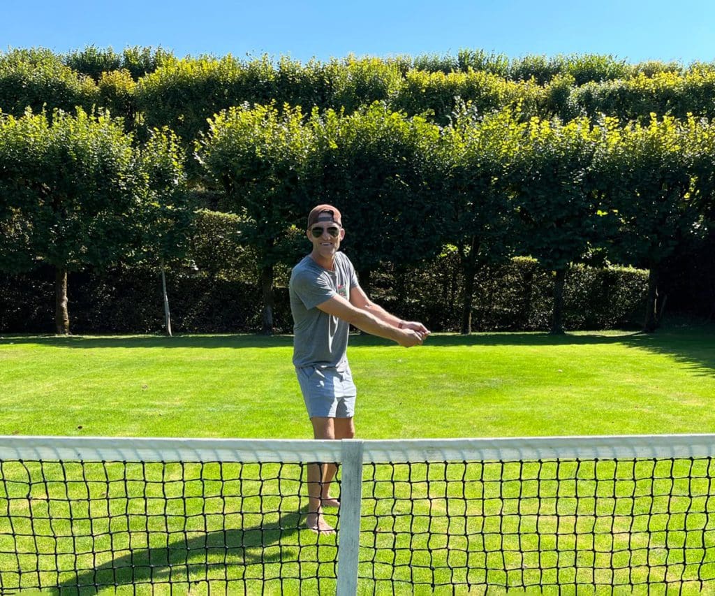 A dad plays tennis across a net at Château de Villandry, one of the best museums in France with kids.