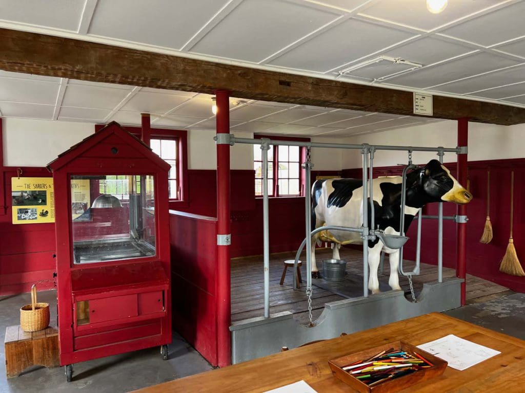 Inside the milking room, featuring several piece of equipment, at Hancock Shaker Village, a stop on this weekend getaway itinerary for families in Pittsfield.