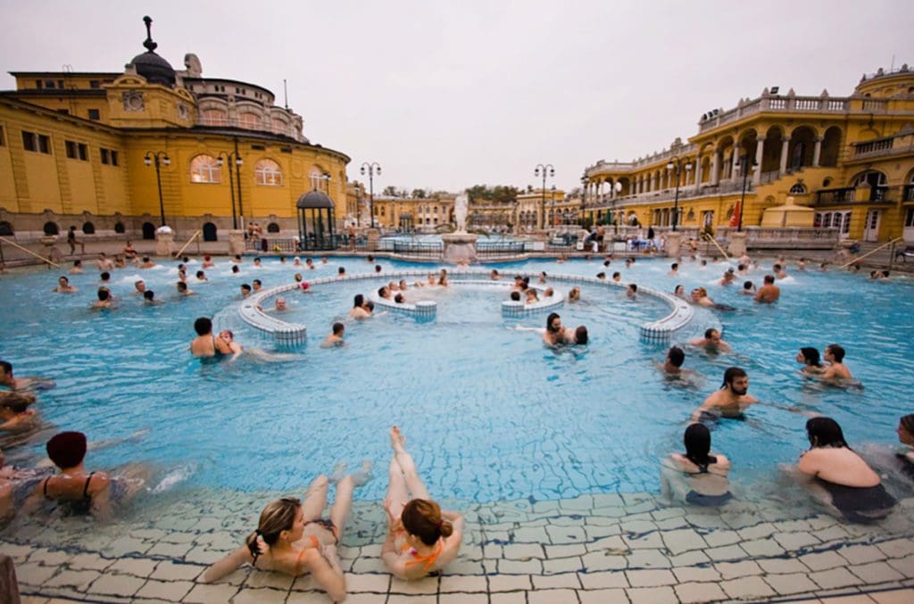Several people enjoy the outdoor baths at Szechenyi Baths.