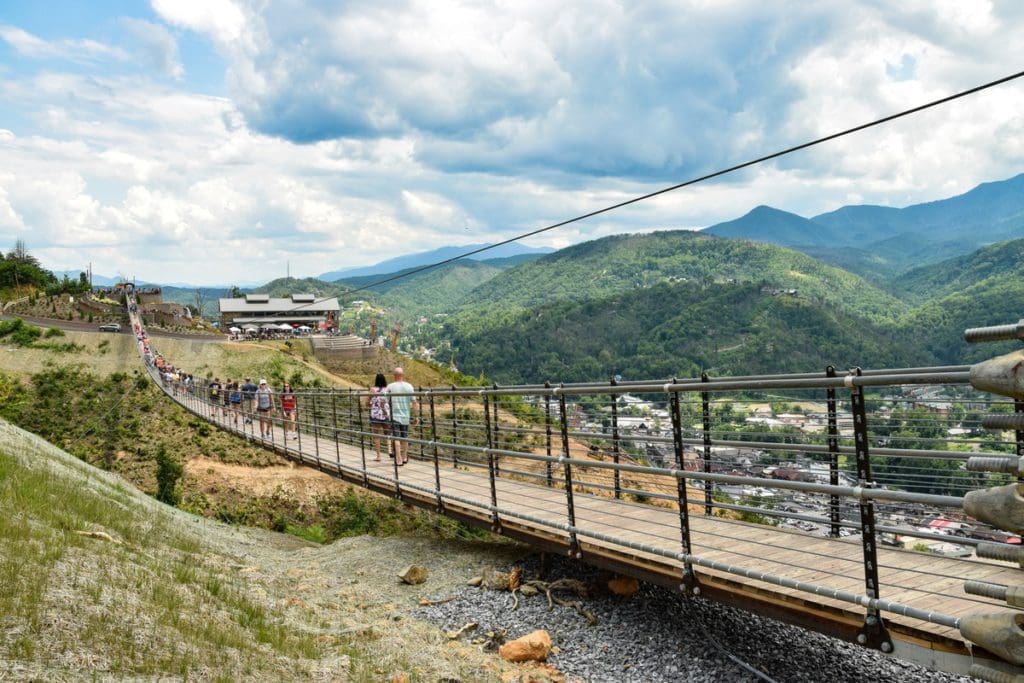 People walk across the large pedestrian swing bridge in Gatlinburg, Tennessee.