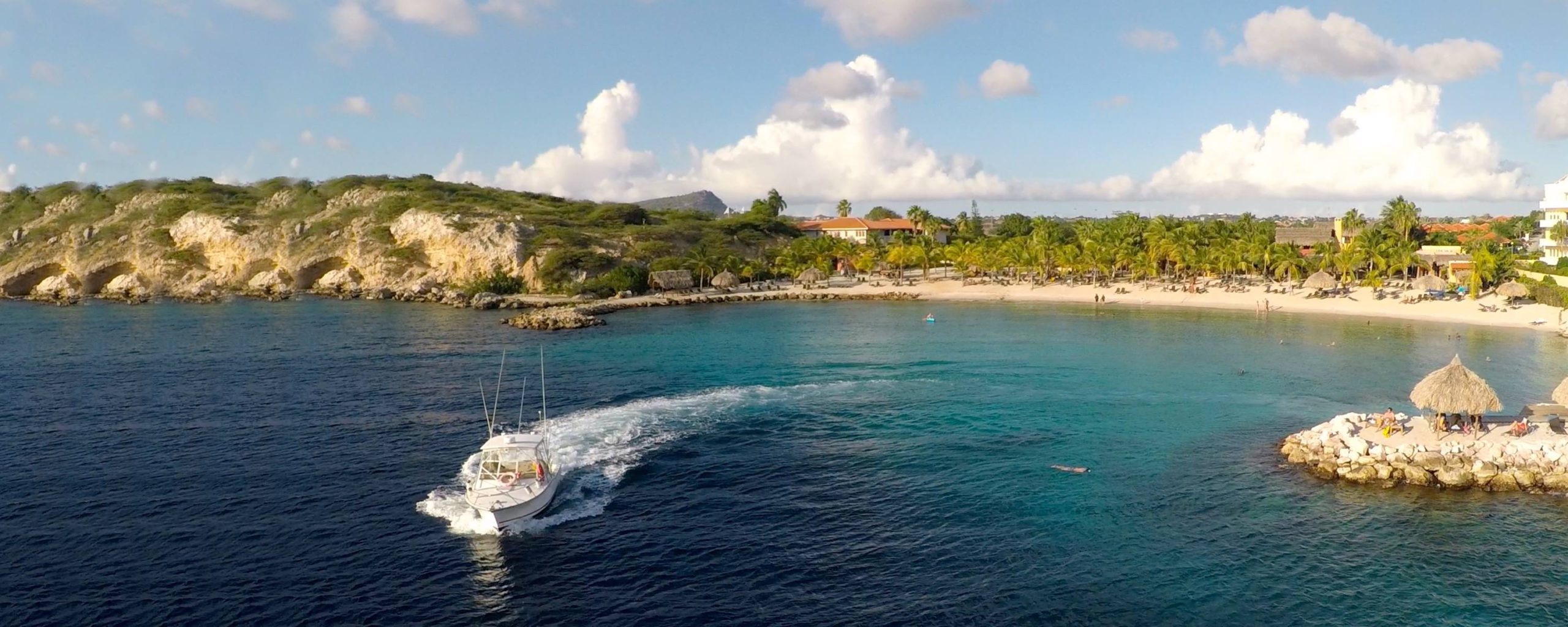 A boat moves away from the shores of Blue Bay Curaçao, one of the best Curacao resort with kids.