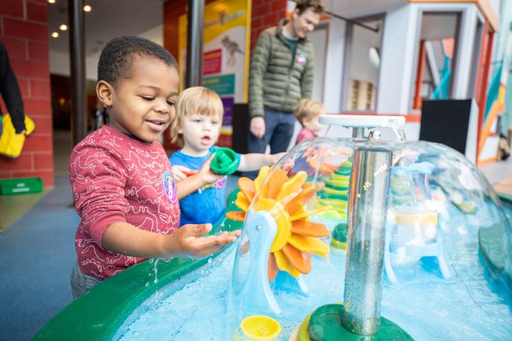 Two boys play in a hands-on water exhibit at the Creative Discovery Museum, one of the best things to do in Chattanooga with kids.