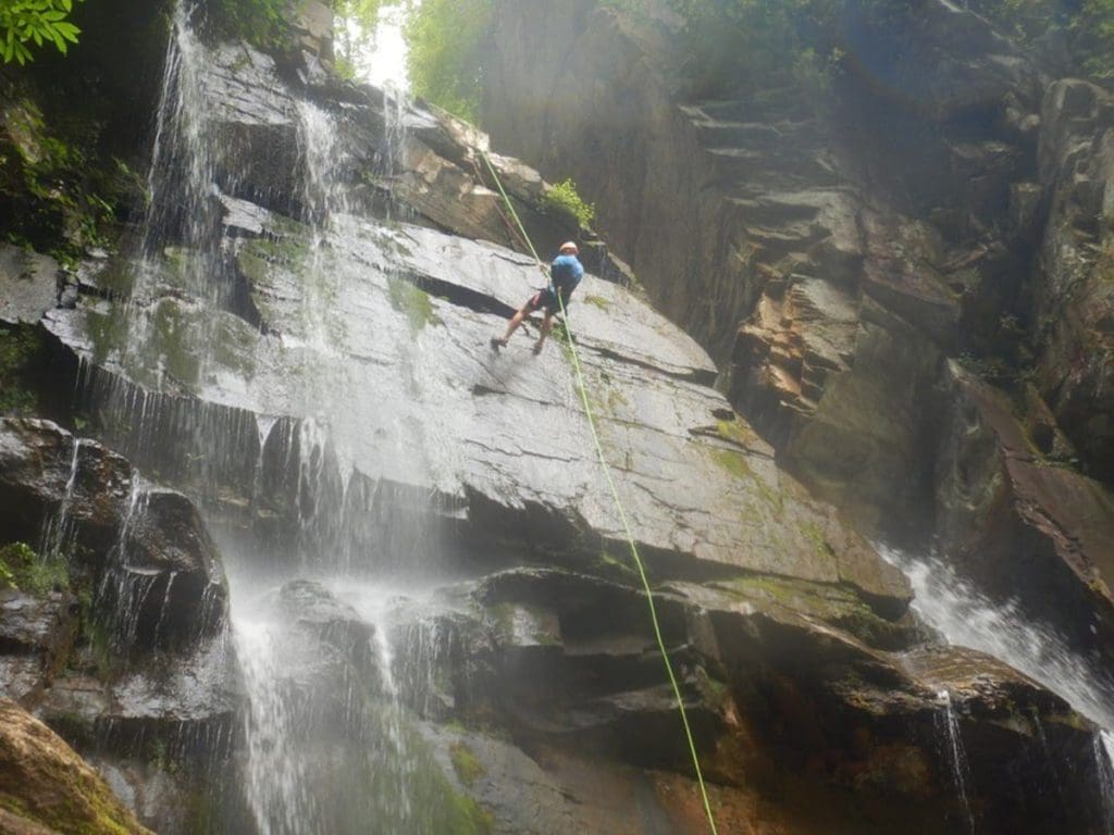 A man repels down the face of a rock while on a tour with Green River Adventures.
